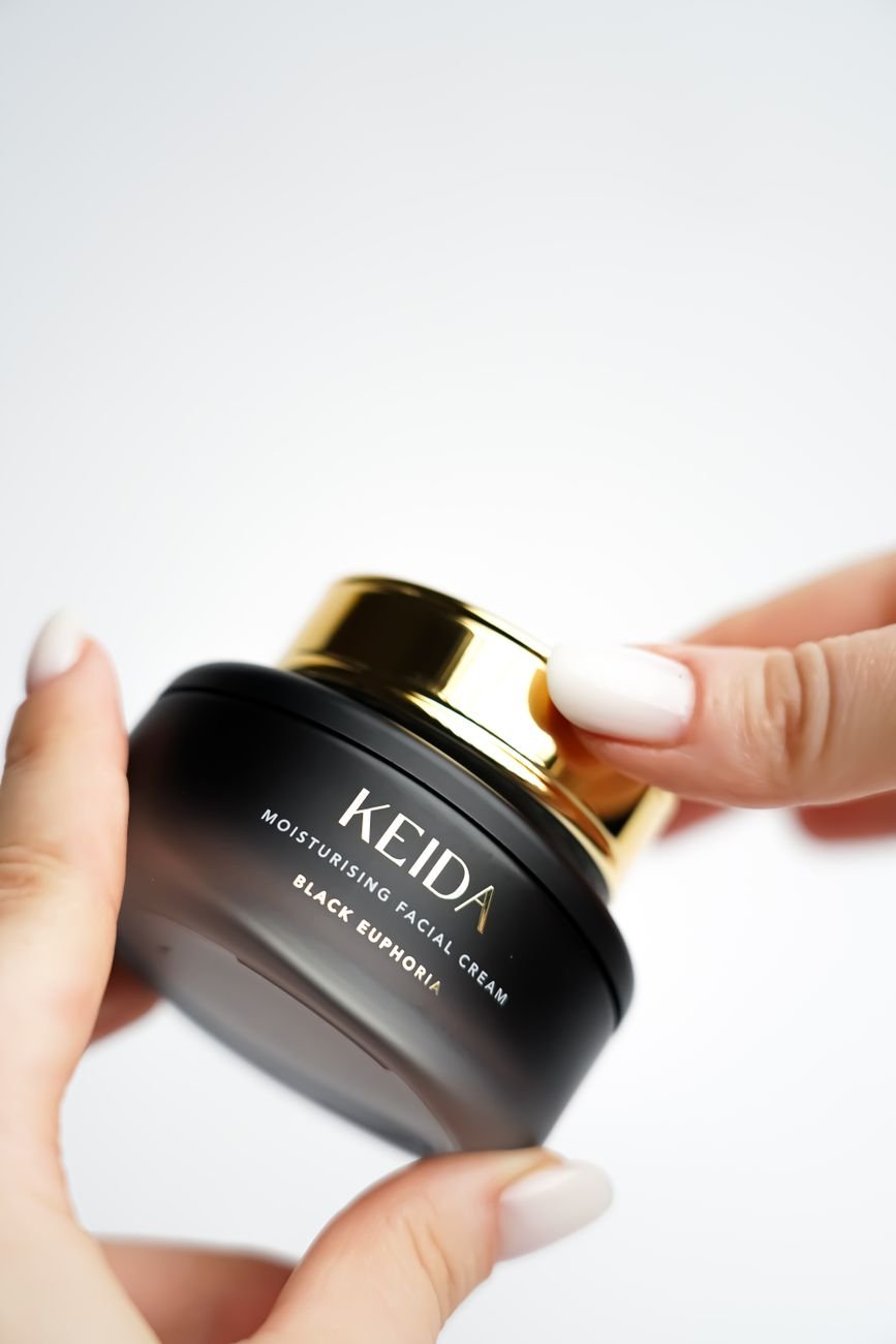 Moisturizing facial cream in a sleek black jar with gold lid, perfect for skincare routines